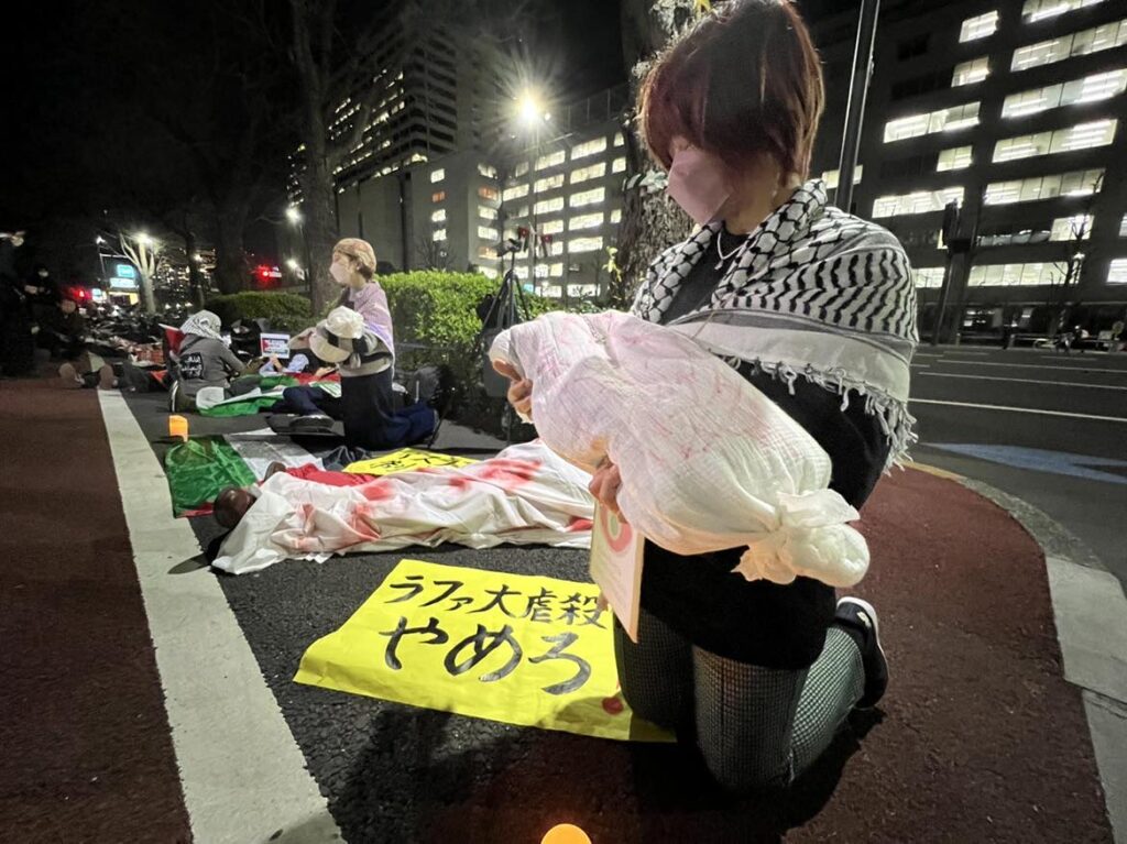 外務省前に赤く染まった遺体袋が置かれる